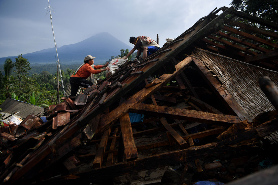 Locals salvage valuables from ruins in Lumajang, East Java on Sunday, after a 6.7 magnitude earthquake levelling the house a day earlier. (Antara Photo/Zabur Karuru)