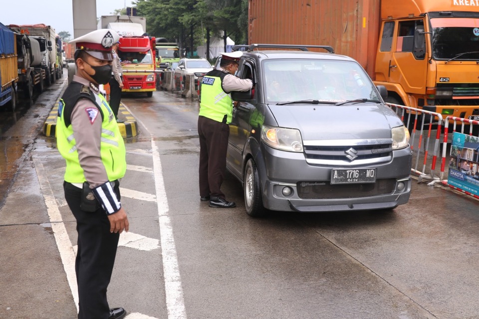 A police officer stops a vehicle at an exodus checkpoint at Cikupa Toll, Tangerang, Banten on May 6, 2021. (B1 Photo/Ruht Semiono)