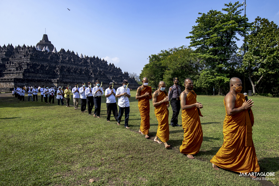 Buddhist monks, followed by devotees, participate in a pradakshina ritual during Vesak celebration at the Borobudur Temple in Central Java, on May 26, 2021. (JG Photo/Yudha Baskoro)