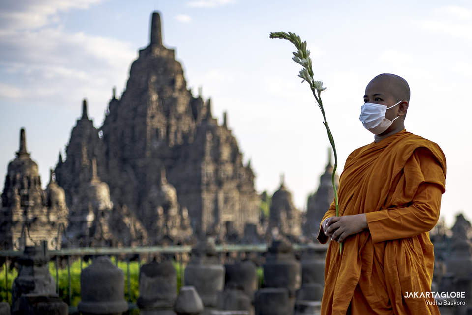 A buddhist monk carries flower during pradakshina ritual at the Sewu Temple in Central Java, on May 26, 2021. (JG Photo/Yudha Baskoro)