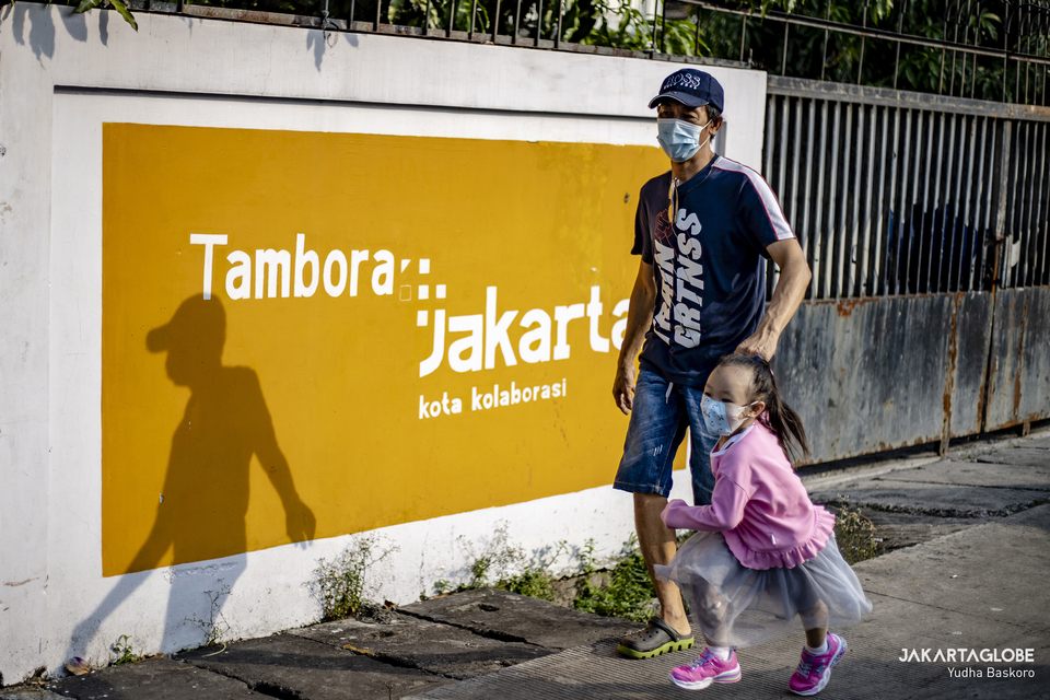 A man walks with his daughter in Tambora neighborhood, West Jakarta on June 3, 2021. (JG Photo/Yudha Baskoro)