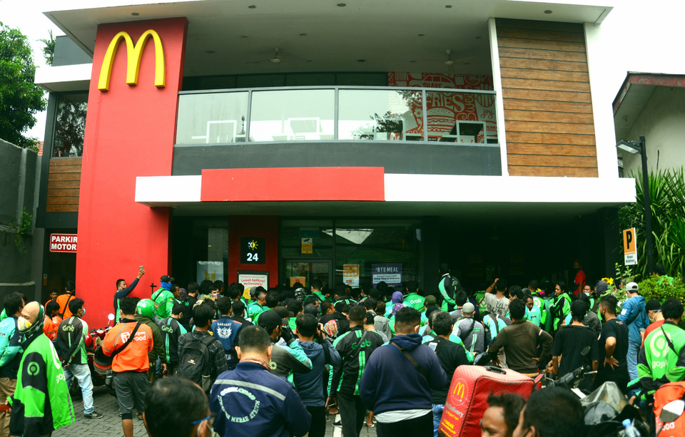 Hundreds of deliverymen from ride-hailing companies form a long line at a McDonald's restaurant in Cikini, Jakarta, for a special menu called BTS Meal on June 9, 2021. (Beritasatu Photo/Joanito De Saojoao)
