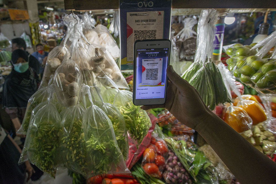 A customer scans a quick response (QR) code to pay for his groceries at Mayestik wet market in Jakarta on May 11, 2021. (Antara Photo/Aditya Pradana Putra)
