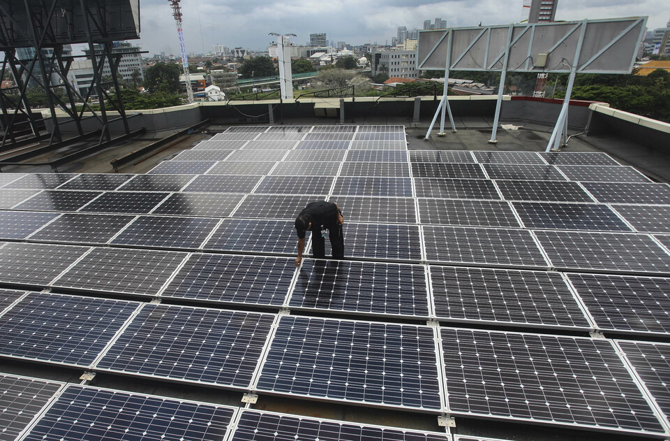 A technician checks on the solar cell placed on the rooftop of the Energy and Mineral Resources Building in Jakarta on March 2, 2016. (Antara Photo/ Muhammad Adimaja)