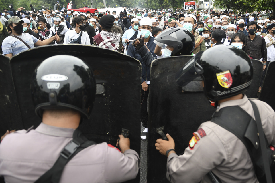 Riot police attempt to control hundreds of Rizieq Syihab's supporters marching to the East Jakarta courthouse on June 24, 2021. (Antara Photo/M Risyal Hidayat)