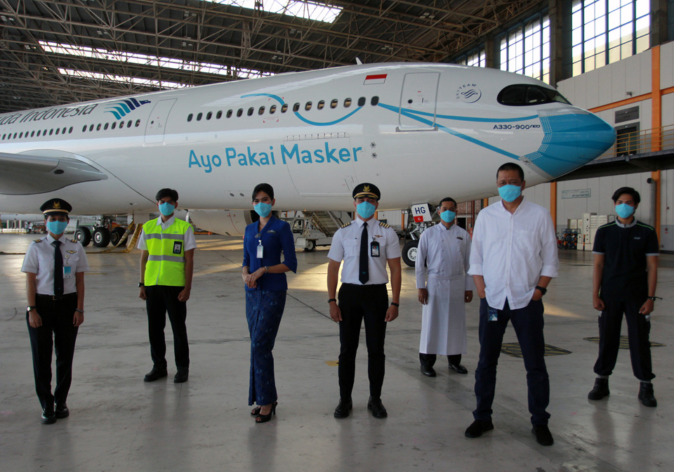 Irfan Setiaputra, Garuda Indonesia's president director, second right, poses for photographs with the airline crew members on Oct 1, 2020. (Antara Photo/Muhammad Iqbal)