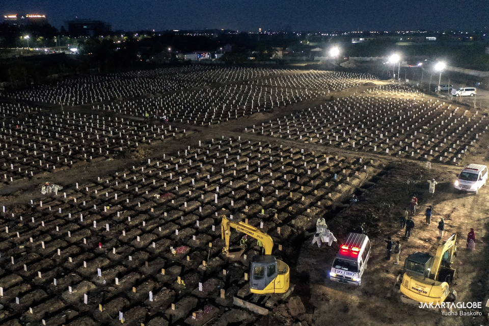 The aerial view of Rorotan Cemetery at dusk on July 23, 2021 shows two excavators are deployed to dig graves for Covid-19 victims. (JG Photo/Yudha Baskoro)
