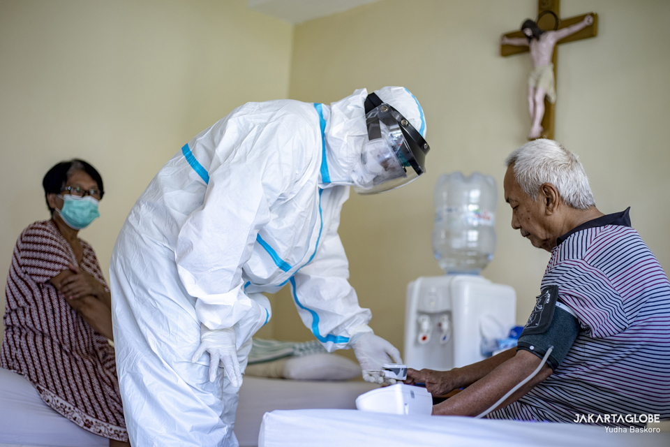 A Covid-19 patient is examined by his doctor at a makeshift isolation facility in Jakarta's Samadi Pastoral Center on August 5, 2021. (JG Photo/Yudha Baskoro)