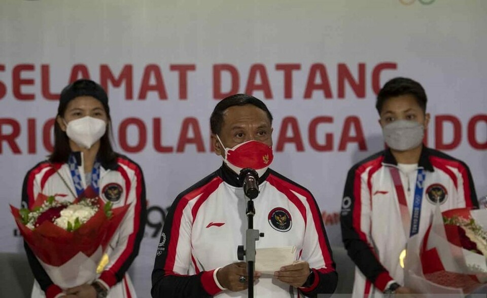Youth Affairs and Sports Minister Zainudin Amali, center, welcomes Tokyo Olympics gold medalists Greysia Polii and Apriyani Rahayu at Soekarno Hatta Airport in Tangerang, Banten, on August 4, 2021. (Antara Photo)