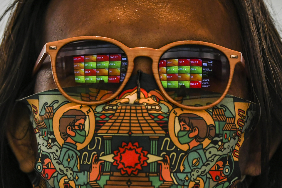 Images of stock price monitors are reflected on glasses worn by an office worker at Indonesia Stock Exchange in Jakarta on Aug 3, 2021. (Antara Photo/Galih Pradipta)