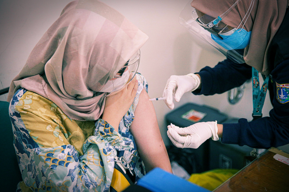 A woman receives a jab of Pfizer vaccine against Covid-19 at Lebak Bulus Public Health Center in East Jakarta on August 23. 2021. (Beritasatu Photo/Joanito De Saojoao)