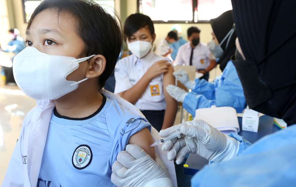 A health worker administers a Covid-19 vaccine to a middle-schooler at SMPN 25 in Depok on September 10, 2021. (Beritasatu Photo/Uthan)
