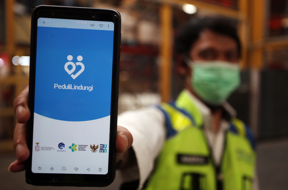 FILE - A security personnel shows Peduli Lindungi app on his cellphone at Soekarno-Hatta International Airport in Tangerang, Banten, August 2, 2021. (Antara Photo/Muhammad Iqbal)