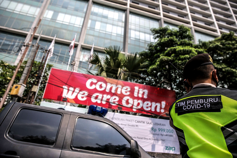 In this April 25, 2021 photo, a policeman stands guard in front of Holiday Inn Hotel in Jakarta where 141 foreigners, most of whom are of Indian nationality, are undergoing 14-day quarantine. (Joanito De Saojoao)