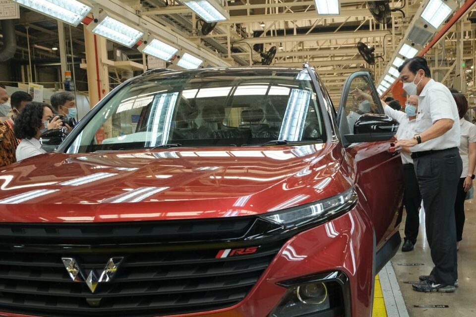 FILE - Chief Investment Minister Luhut Binsar Pandjaitan, right, looks into a car at Wuling Motors assembly plant in Cikarang, West Java, Sept. 30, 2021. (Photo courtesy of Wuling Motors)