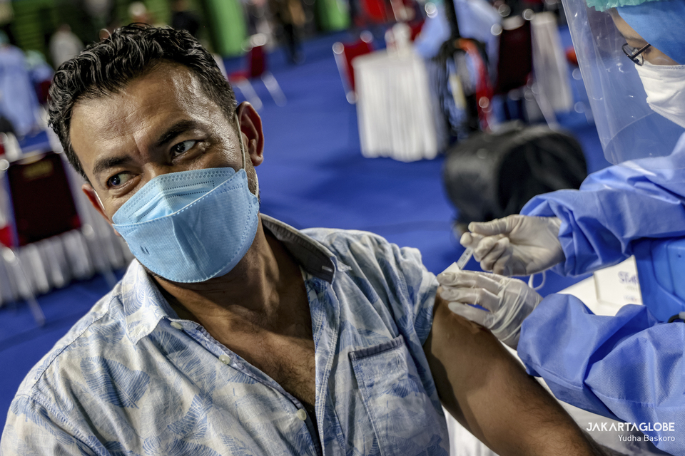 A man receives a Covid-19 vaccine dose during a mass vaccination program for refugees and asylum seekers at Bulungan sports hall in South Jakarta on October 7, 2021. (JG Photo/Yudha Baskoro)