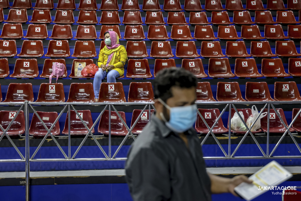 A woman sits inside Bulungan sports hall in South Jakarta during a mass vaccination program for refugees and asylum seekers on October 7, 2021. (JG Photo/Yudha Baskoro)