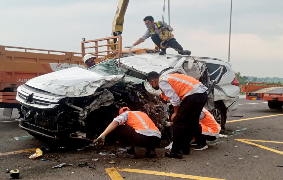 Toll road workers try to pull the wreck of a Mitsubishi Pajero after an accident that killed actress Vanessa Angel and her husband in Jombang, East Java, on November 4, 2021. (Antara Photo)