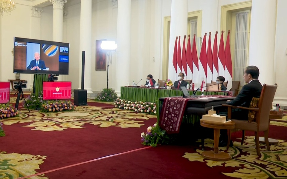 President Joko Widodo, right, follows a televised speech by Joe Biden at the Bogor Palace during the Summit for Democracy held virtually and hosted by the US president on Dec. 9, 2021. (Videography)