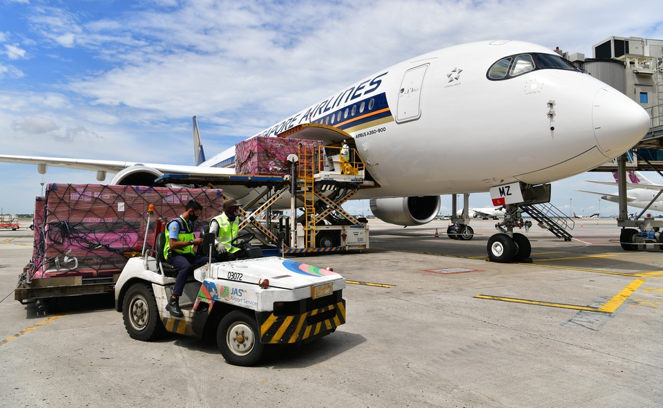Airport workers unload Moderna Covid-19 vaccines from a Singapore Airlines plane at Soekarno-Hatta International Airport in Tangerang, Banten, December 26, 2021. (Photo courtesy of the Information and Communication Ministry)