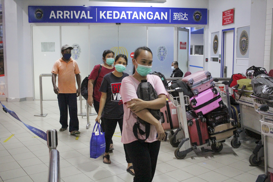 Visitors walk pass an immigration check point at the Batam International Port on January 3, 2022. (Antara Photo/Teguh Prihatna)
