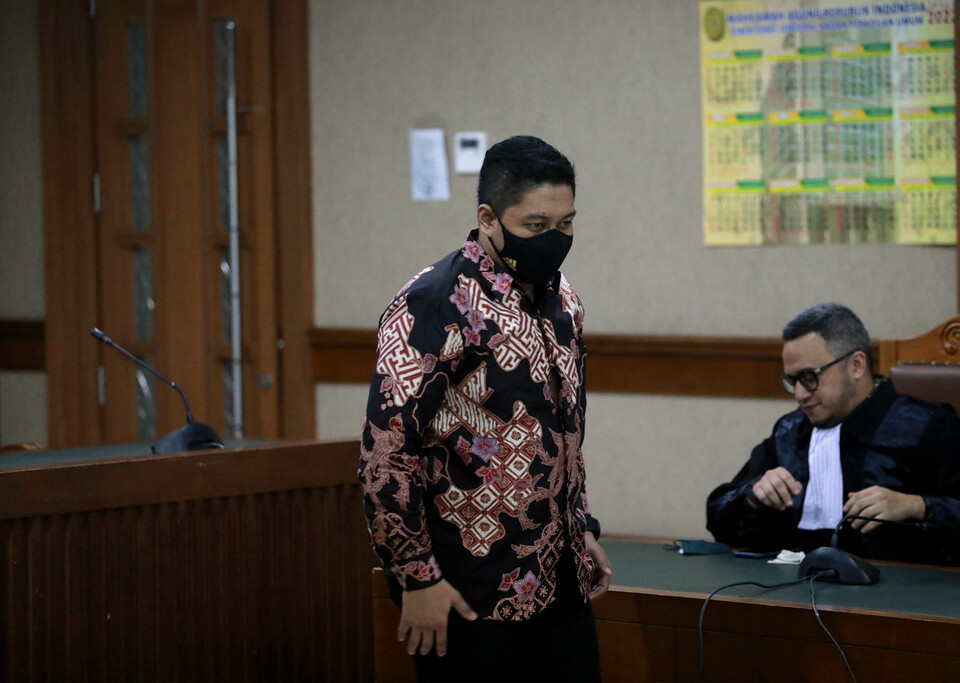 Former KPK investigator Stepanus Robin Pattuju, left, talks to his attorney during a hearing at the Jakarta Anti-Corruption Court, January 12, 2022. (Beritasatu Photo/Joanito De Saojoao)