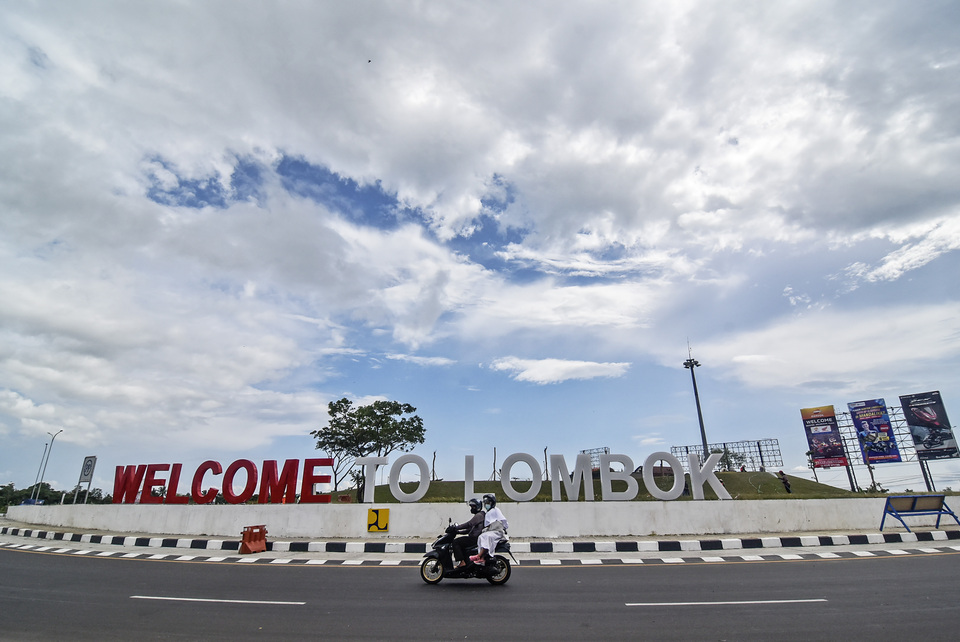Motorcycle riders pass by welcome to Lombok sign in front of Lombok International Airport in Central Lombok, West Nusa Tenggara on Monday, Feb 7, 2022. (Antara Photo/Ahmad Subaidi)
