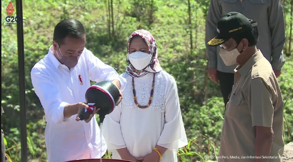 Jokowi pours water from Special Region of Yogyakarta into a large jug made of copper during the Kendi Nusantara ritual at the kilometer zero-point of new state capital Nusantara in East Kalimantan on March 14, 2022. (JG Screenshot)
