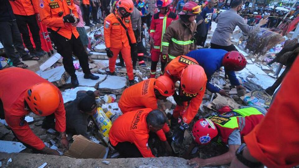 Rescue workers dig the debris in search of victims after an Alfamart store in Banjar, South Kalimantan, collapses on April 18, 2022. (Antara Photo)