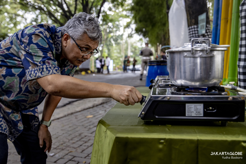 FILE - A man lits his bio methane gas stove at Talangagung Landfill in Malang Regency City Hall, East Java, on May 18, 2022. (JG Photo/Yudha Baskoro)