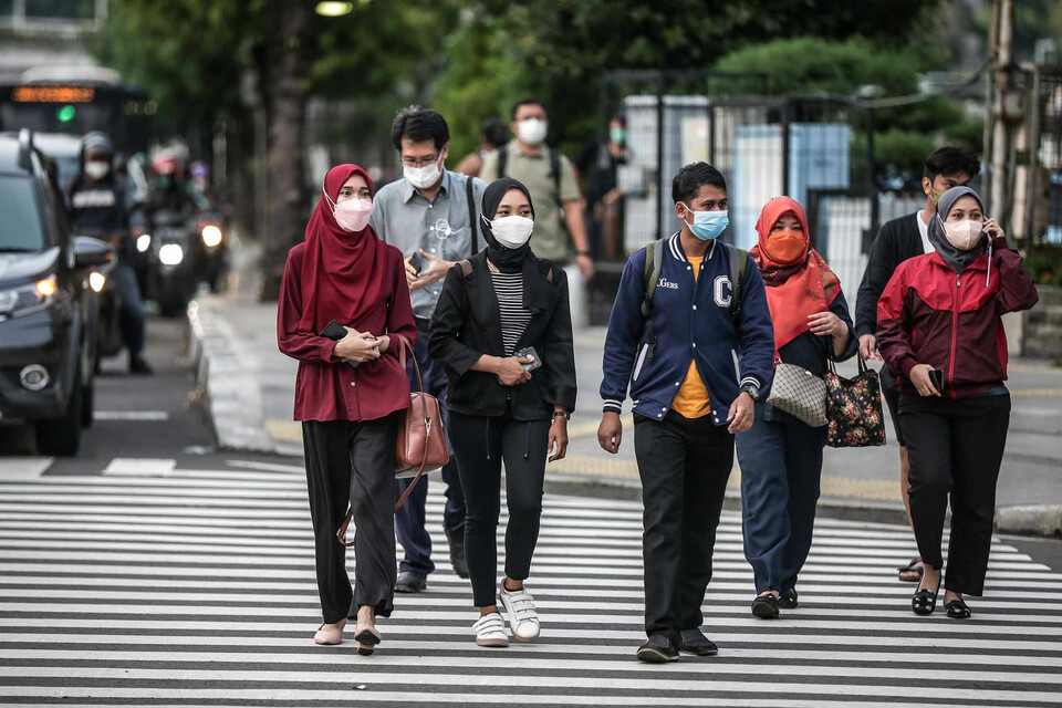 Workers crossing the pelican cross in the Sudirman area, Jakarta, on Wednesday, May 18, 2022. Deputy Finance Minister Thomas Djiwandono said that the Covid-19 pandemic has caused a significant decline in Indonesia's middle class, which continues to struggle with the lasting economic impact.(BeritaSatuPhoto/Joanito De Saojoao).