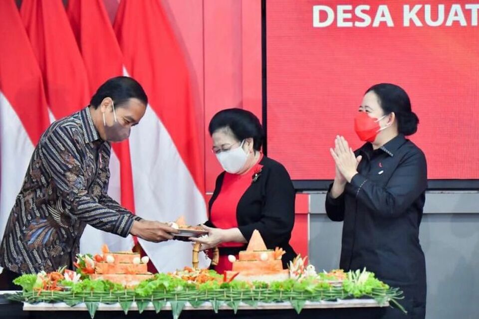 President Joko Widodo, left, hands the tip of tumpeng (ceremonial dish of rice served in a cone shape) to PDIP Chairwoman Megawati Soekarnoputri during his surprise birthday celebration in Jakarta on June 21, 2022. (Antara Photo)
