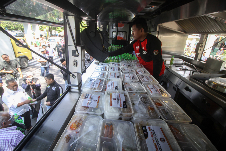Volunteers distribute free meals provided by charity organization Aksi Cepat Tanggap (ACT) at Sidoarjo Great Mosque complex in East Java on June 10, 2022. (Antara PhotoUmarul Faruq)