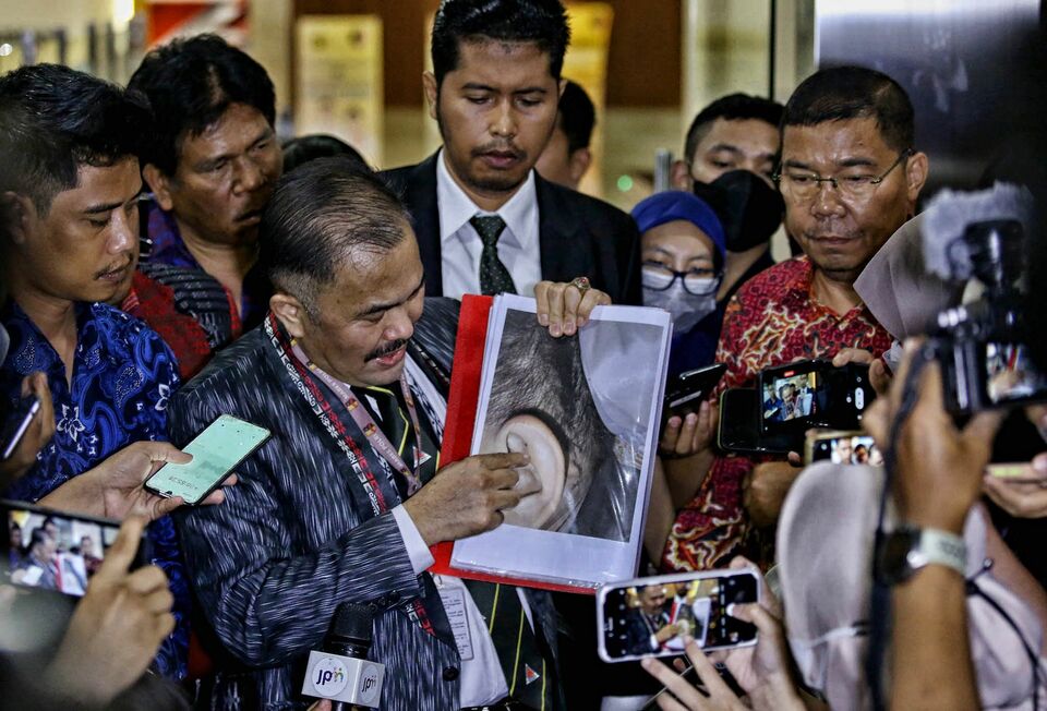 Lawyer Kamaruddin Simanjuntak shows a photograph from the postmortem report on slain police officer Nopryansyah Yosua Hutabarat at the National Police headquarters in Jakarta on July 18, 2022. (Joanito De Saojoao)