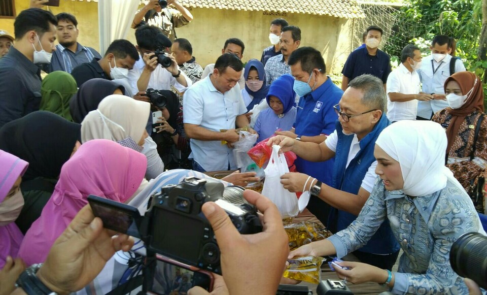 In this photo taken on July 9, 2022, Trade Minister Zulkifli Hasan distributes government-branded cooking oil Minyakita in Bandar Lampung accompanied by daughter Futri Zulya Savitri, right. (Beritasatu Photo)