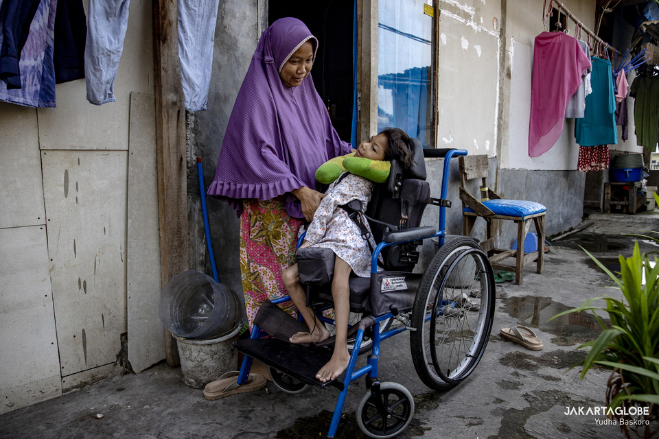 A woman accompanies his daughter in front of their home at Kampung Apung, North Jakarta on June 22, 2022. (JG Photo/Yudha Baskoro)