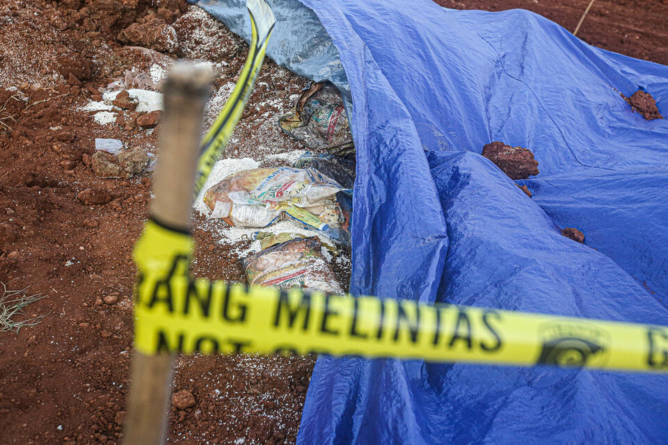 A police line is placed on land where sacks of government humanitarian supplies are unearthed in Depok, West Java, on July 31, 2022/ (Beritasatu Photo/Joanito De Saojoao)