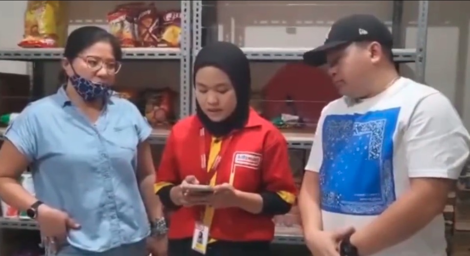 In this video capture, an Alfamart employee, center, reads a public apology prepared by the alleged shoplifter identified as Mariana, left, and her lawyer at an Alfmarat shop in South Tangerang. (Videography)