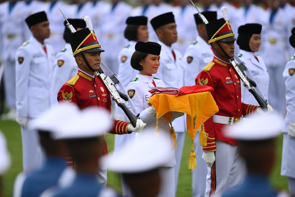 FILE - I Dewa Ayu Firsty Meita Dewanggi, center, a member of the elite national flag raiser team, or Paskibraka, carries the flag during the ceremony to commemorate the 77th Indonesian anniversary at the State Palace in Jakarta on August 17, 2022. (Antara Photo/Sigid Kurniawan)