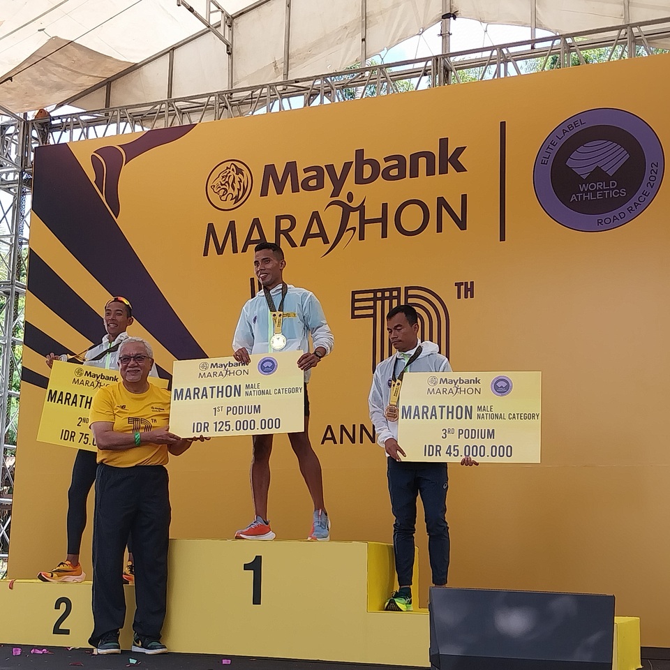 Rikki Marthin Luther Simbolon stands on top of the podium for men's marathon national open category at the Maybank Marathon 2022 in Bali Safari & Marine Park, Gianyar, on Aug. 28, 2022. (JG Photo/Jayanty Nada Shofa)