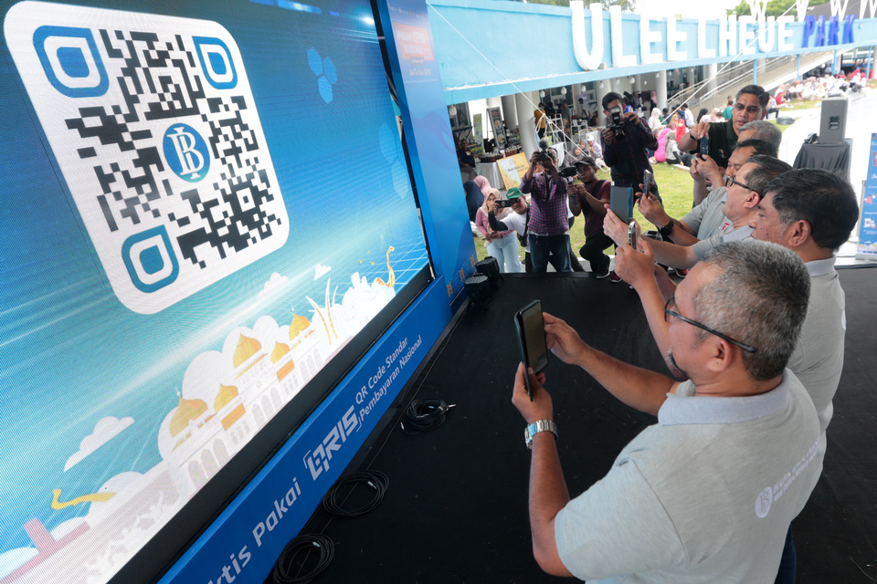 Bank Indonesia officials and Acting Mayor of Banda Aceh Bakri Siddiq, third right, scan a quick response (QR) code during a celebration of the national QRIS week in Banda Aceh, Aceh on Aug 20, 2022. (Antara Photo/Irwansyah Putra)