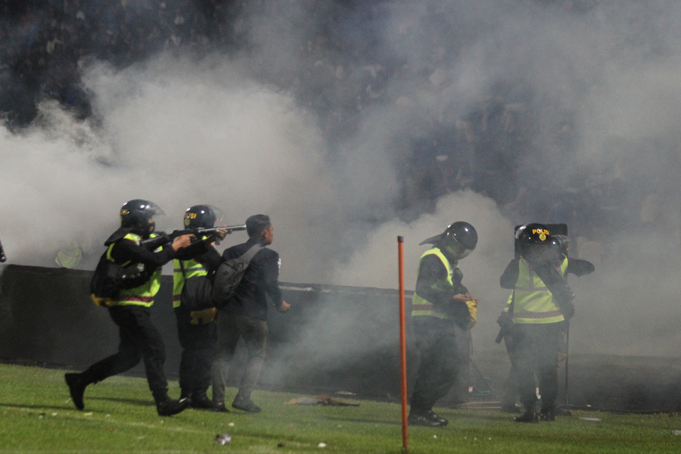 Police use tear gas to prevent Arema Football Club supporters from invading the pitch frollowing a match with visiting Persebaya Surabaya at the Kanjuruhan Stadium in the East Java town of Malang on October 1, 2022. (Antara Photo/Bowo Sucipto)