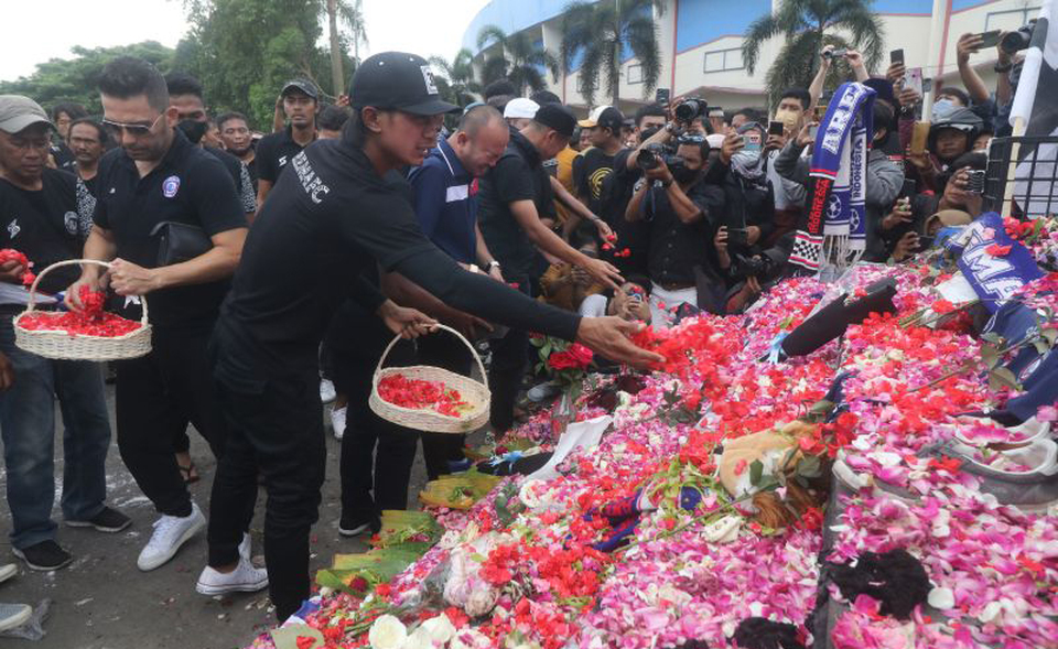 Arema Football Club players and officials strew flowers at the Kanjuruhan Stadium in the East Java town of Malang on Oct. 3, 2022, paying tribute to at least 131 people who died during post-match clashes between fans and security officials in the stadium two days earlier. (Antara Photo)