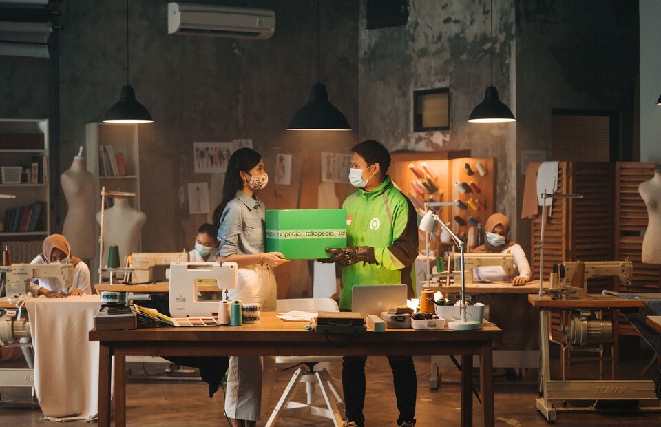 A handout photograph shows models enacting package delivery. (Photo courtesy of GoTo)