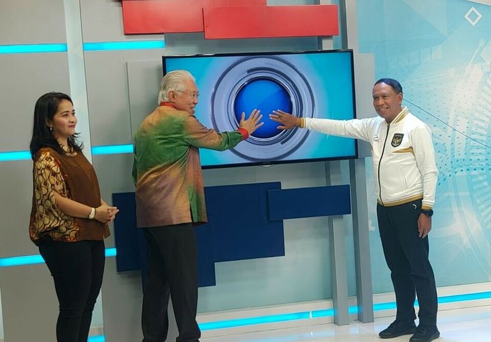 Youth Affairs and Sports Minister Zainudin Amali, right, presses a button together with B-Universe Executive Chairman Enggartiasto Lukita who is accompanied by Managing Director Apreyvita Wulansari to symbolically launch World Cup special program Semesta Bola at BTV studio in Jakarta on November 11, 2022. (David Gita Roza)