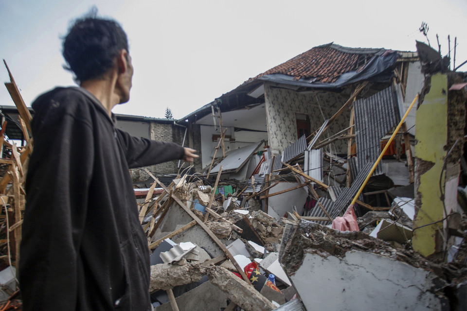 A villager points to his collapsed home after an earthquake that rocked the West Java town of Cianjur on November 21, 2022. (Antara Photo/Yulius Satria Wijaya)