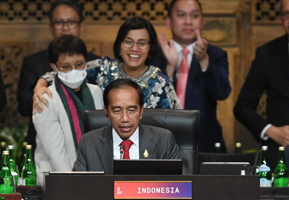President Joko WIdodo, center, delivers a speech to conclude the  G20 Summit as Finance Minister Sri Mulyani hugs Foreign Minister Retno Marsudi on the background in Bali on November 16, 2022. (Antara photo)