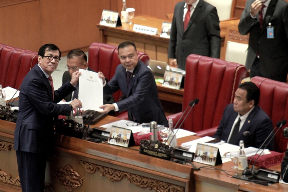 Justice Minister Yasonna Laoly, left, hands the draft of the bill on the Criminal Code to House of Representatives Deputy Speaker Sufmi Dasco Ahmad during a plenary session at the legislature building in Jakarta on December 6, 2022. (B-Universe Photo/Mohammad Defrizal)