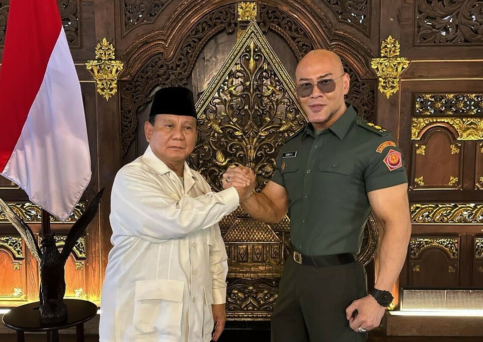 YouTube personality Deddy Corbuzier, right, shakes hands with Defense Minister Prabowo Subianto in this photo he posted on Instagram on December 10, 2022.