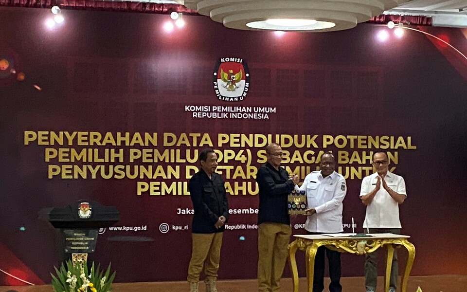 Home Affairs Minister Deputy John Wempi Wetipo, second right, symbolically hands documents of voters to General Election Commission (KPU) Chairman Hasyim Asyari at the KPU building in Jakarta on December 14, 2022. (B-Universe Photo/Ichsan Ali)